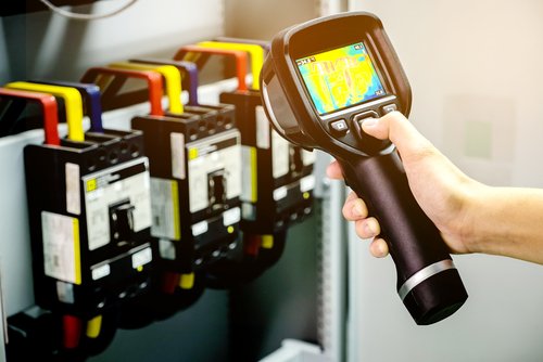 Leer Electric technician using thermography technology to spot potential issues